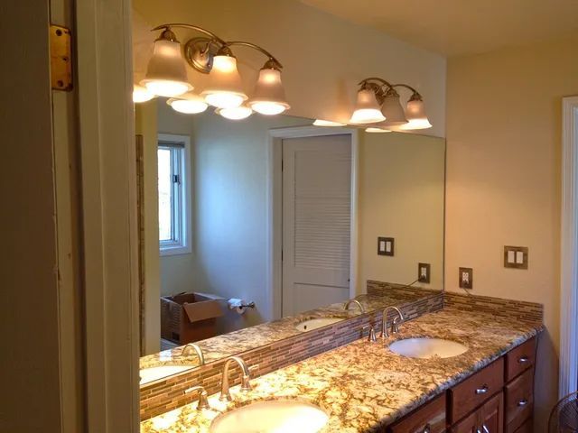 A bathroom with two sinks and a large mirror