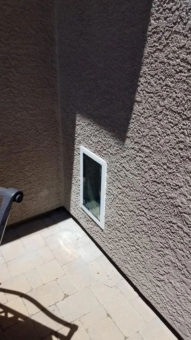 A pet door is installed on the side of a building