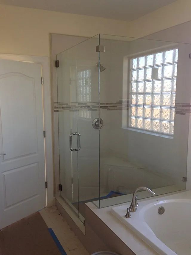 A bathroom with a walk-in shower with a glass door