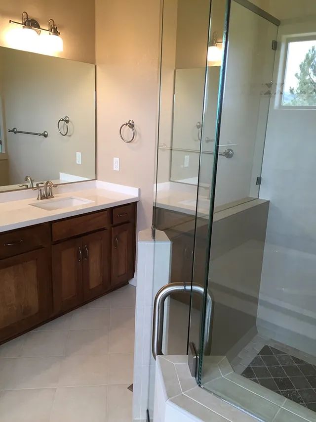 A bathroom with two sinks and a walk-in shower