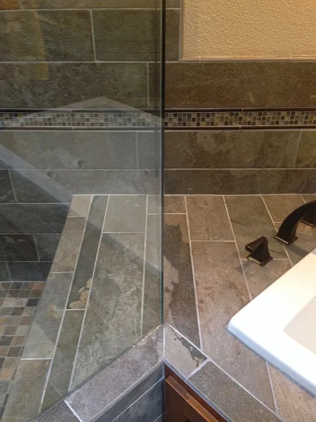 A bathroom with a glass enclosure focusing on a shower bench