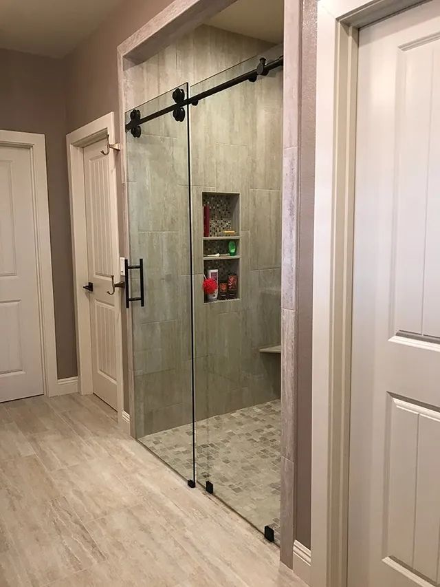 A bathroom with a walk-in shower and sliding glass doors
