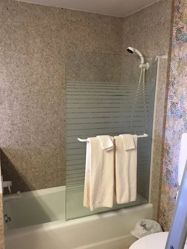 A bathroom with a bathtub, toilet, shower and towels