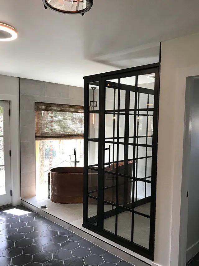 A bathroom with a black-framed shower