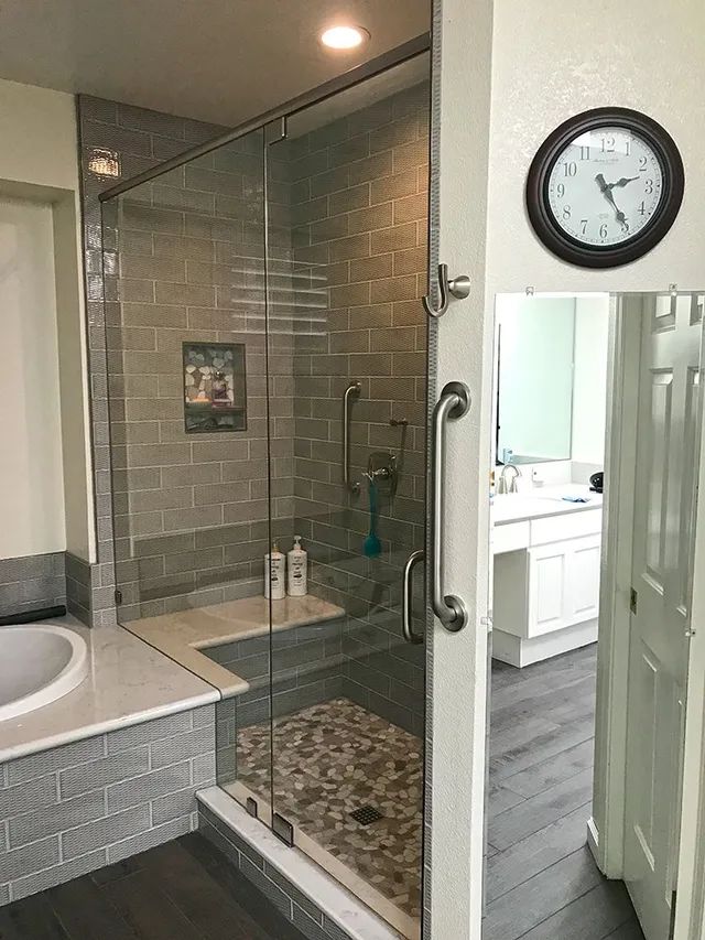 A bathroom with a walk-in shower and a clock on the wall