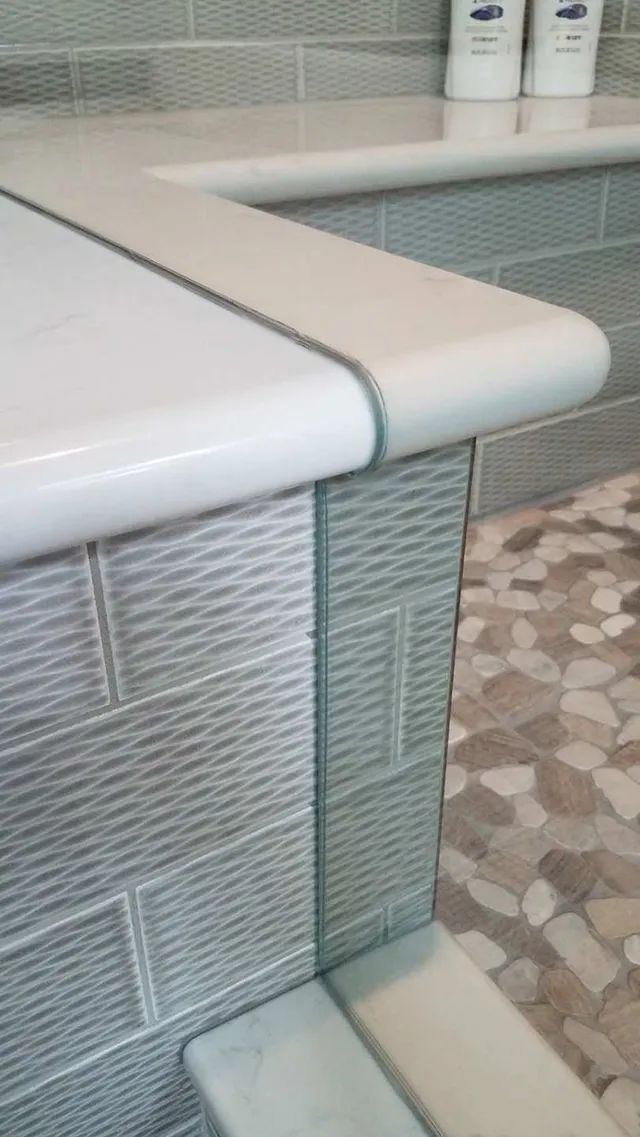 A shower bench separated by a glass enclosure