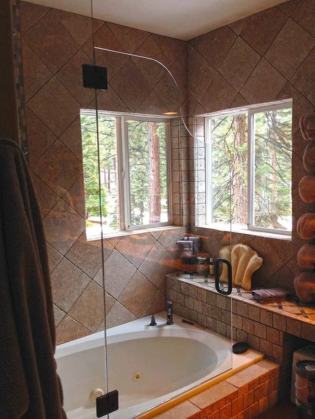 A bathroom with a tub and a glass shower door