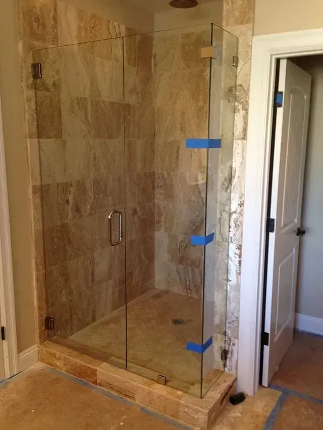 A glass shower door is being installed in a bathroom