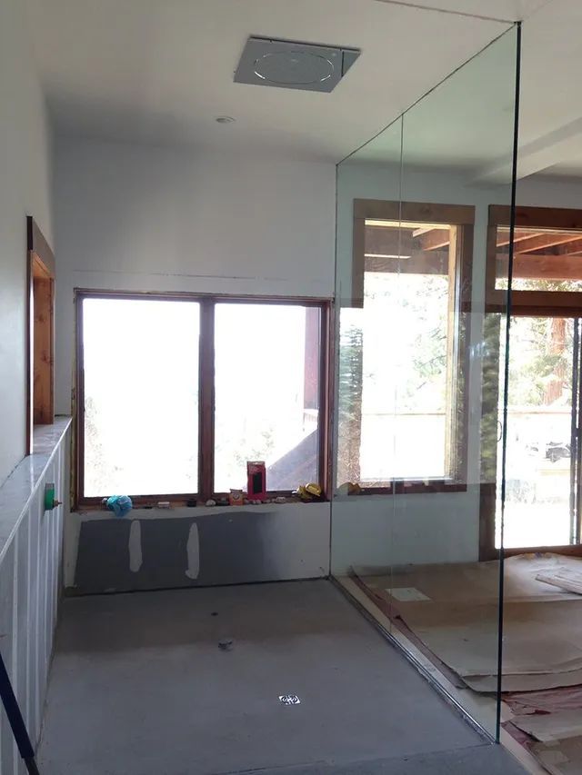 An unfinished installation of a glass wall for a bathroom shower