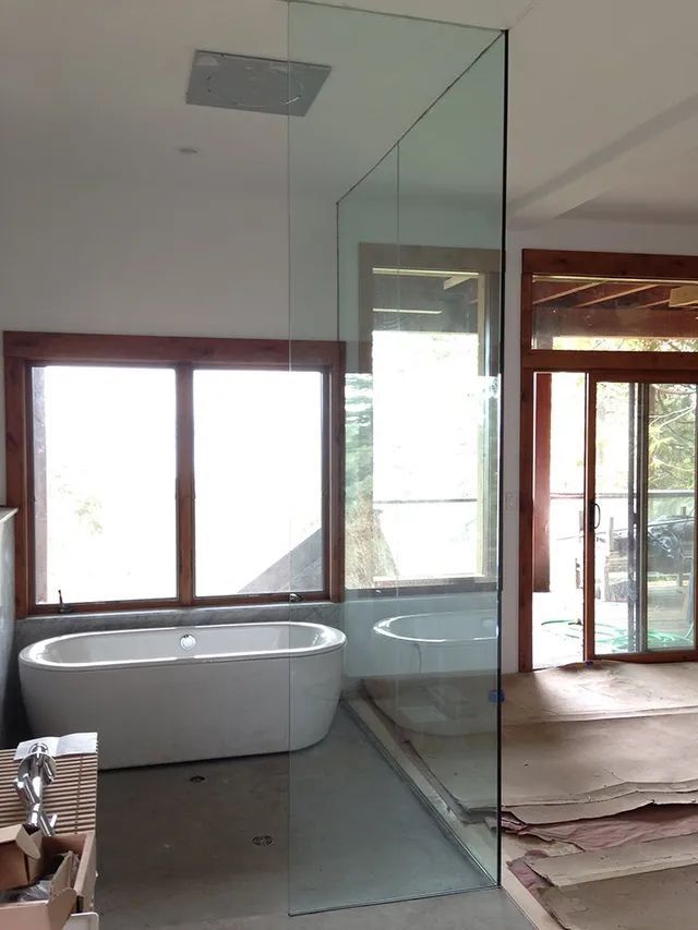 An unfinished installation of a bathroom shower with a tub