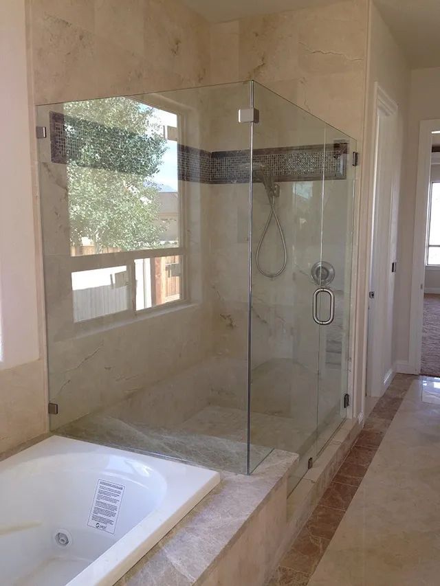 A bathroom with a tub and a shower with a glass door