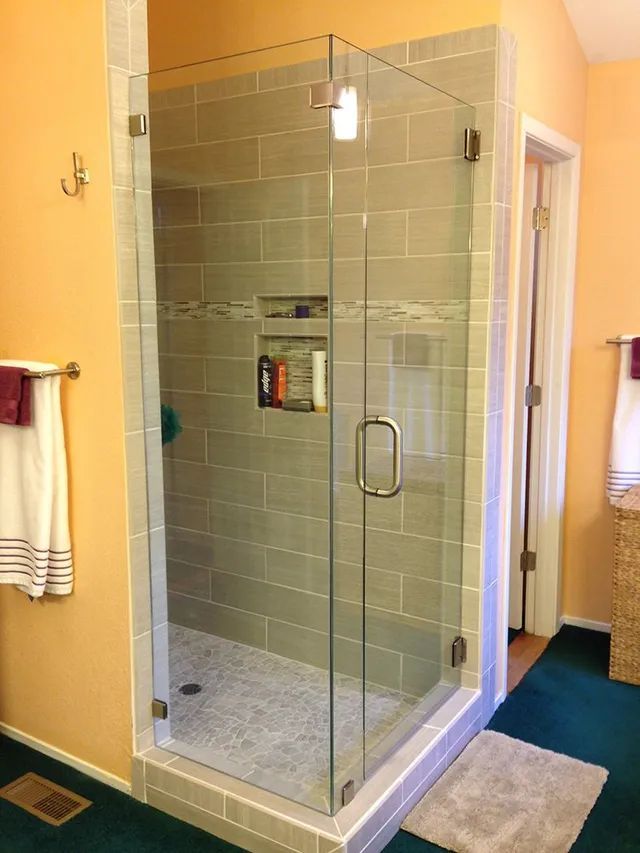 A bathroom with a walk-in shower with a glass door