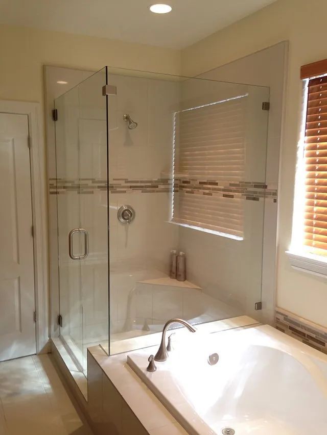 A bathroom with a tub and a shower with a glass door