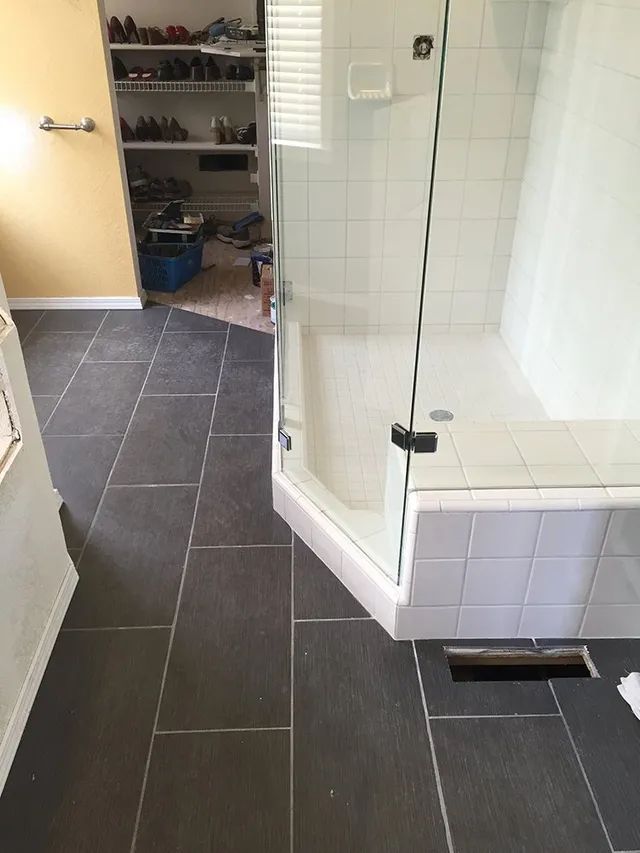 A bathroom with a walk-in shower with a glass door
