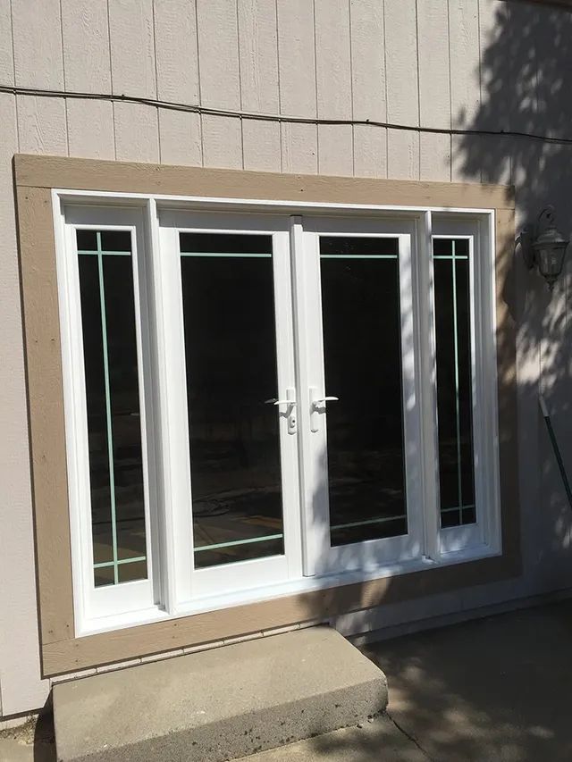 A white sliding glass door is on the side of a house