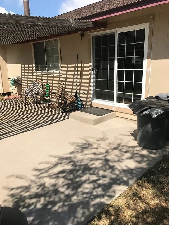 The backyard of a house with a patio and sliding glass doors