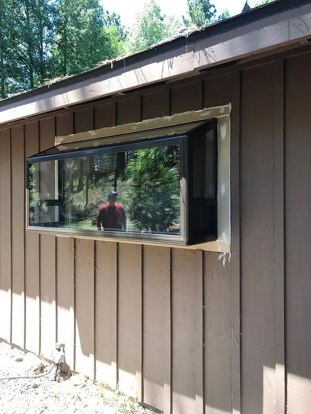 A brown house with a large window on the side of it