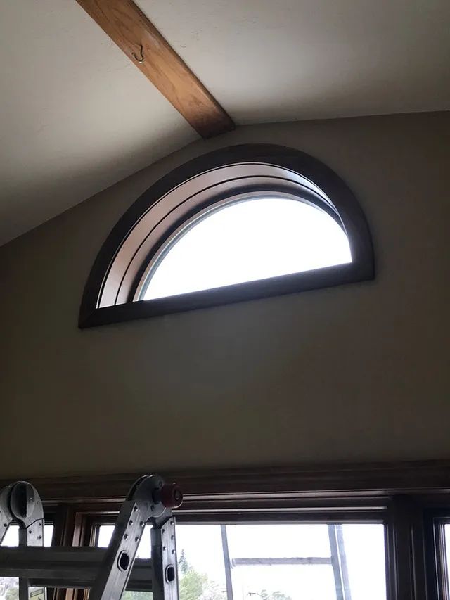 An arched window with a ladder in front of it