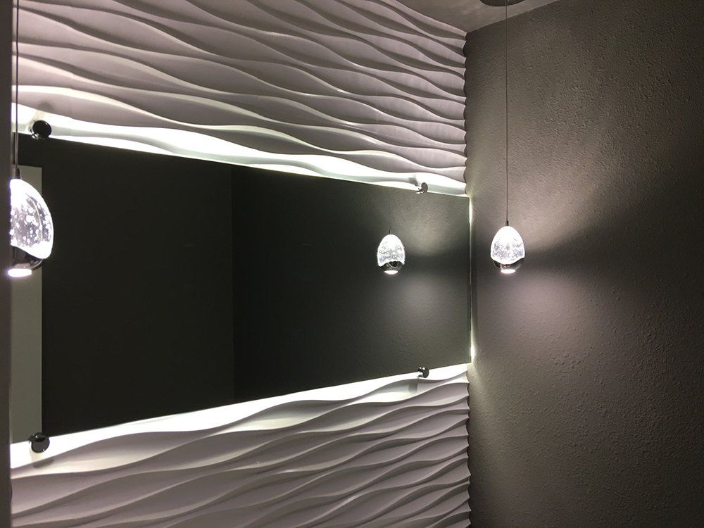 A bathroom with a large mirror and lights on the wall