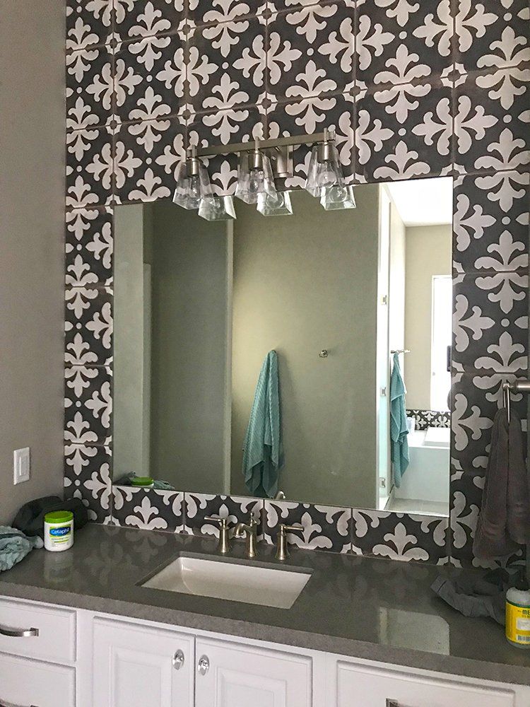 A bathroom with a large mirror and a sink