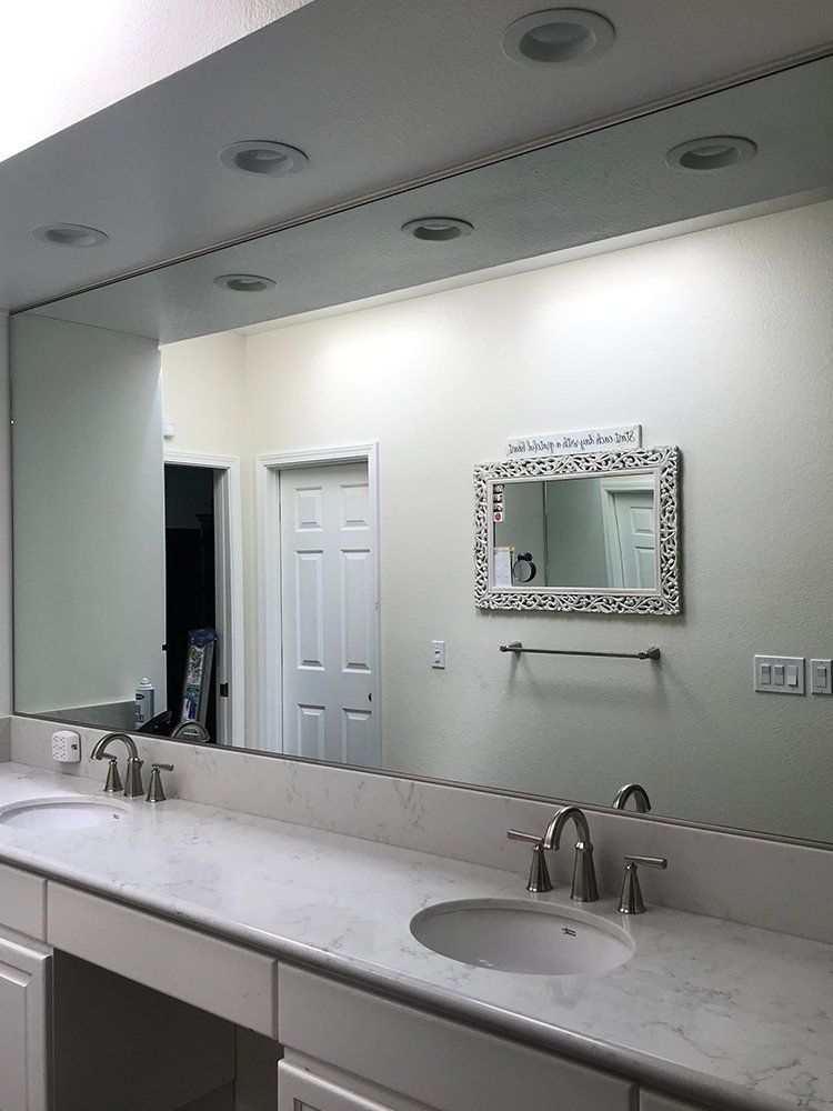 A bathroom with two sinks and a large mirror on the wall