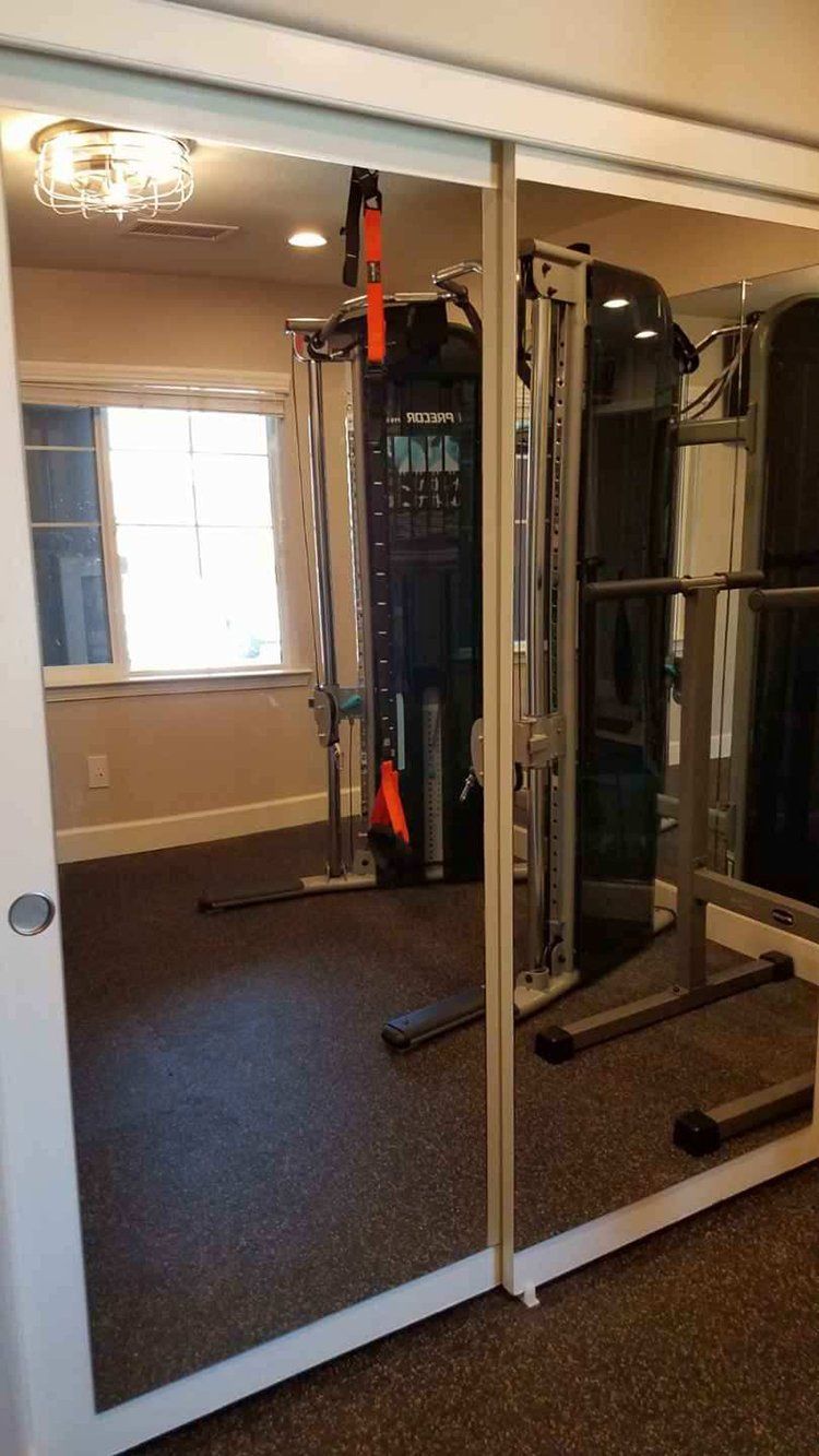 A gym with a sliding glass door and a large mirror