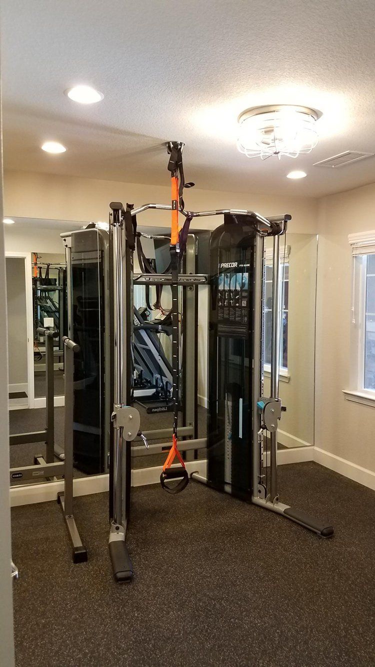 A gym with a lot of equipment and a large mirror