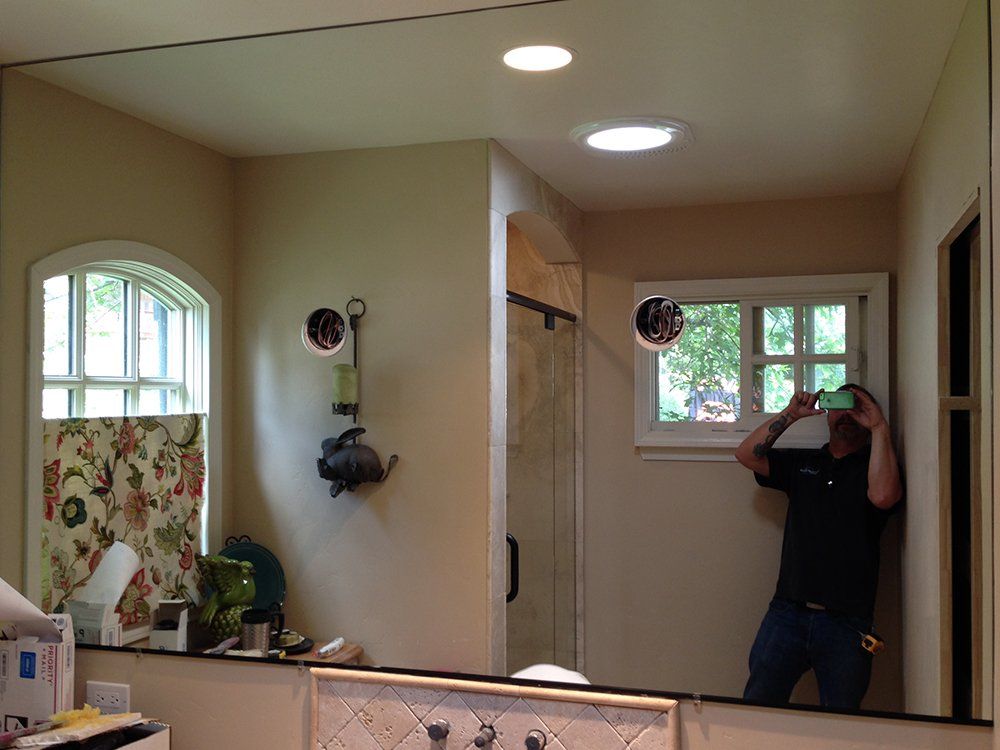 A man is taking a picture of himself in a bathroom mirror