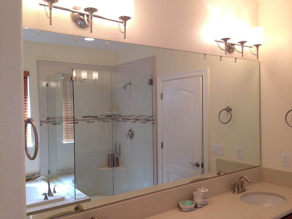 A bathroom with a large mirror and a sink
