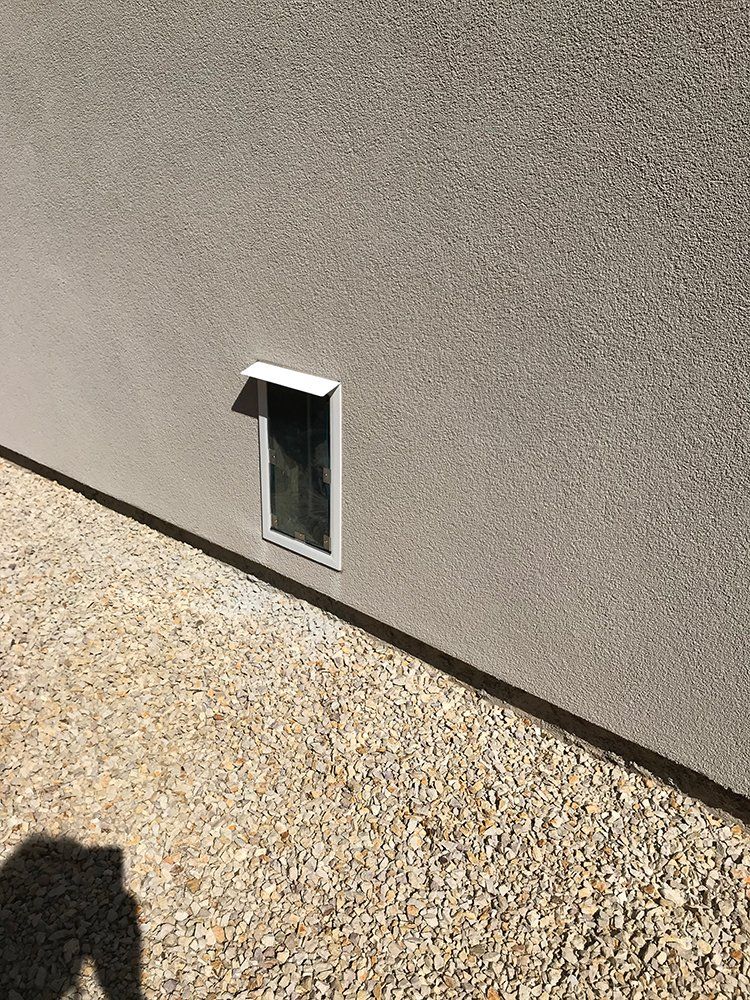 There is a dog door on the side of a building
