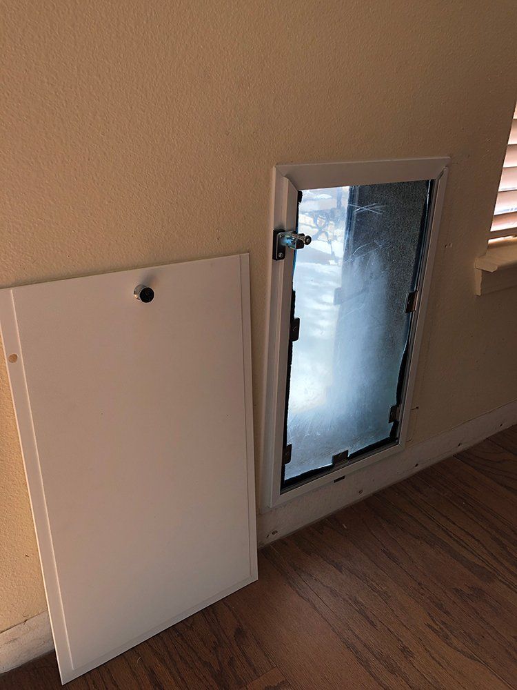 A white dog door is sitting on a wooden floor next to a window