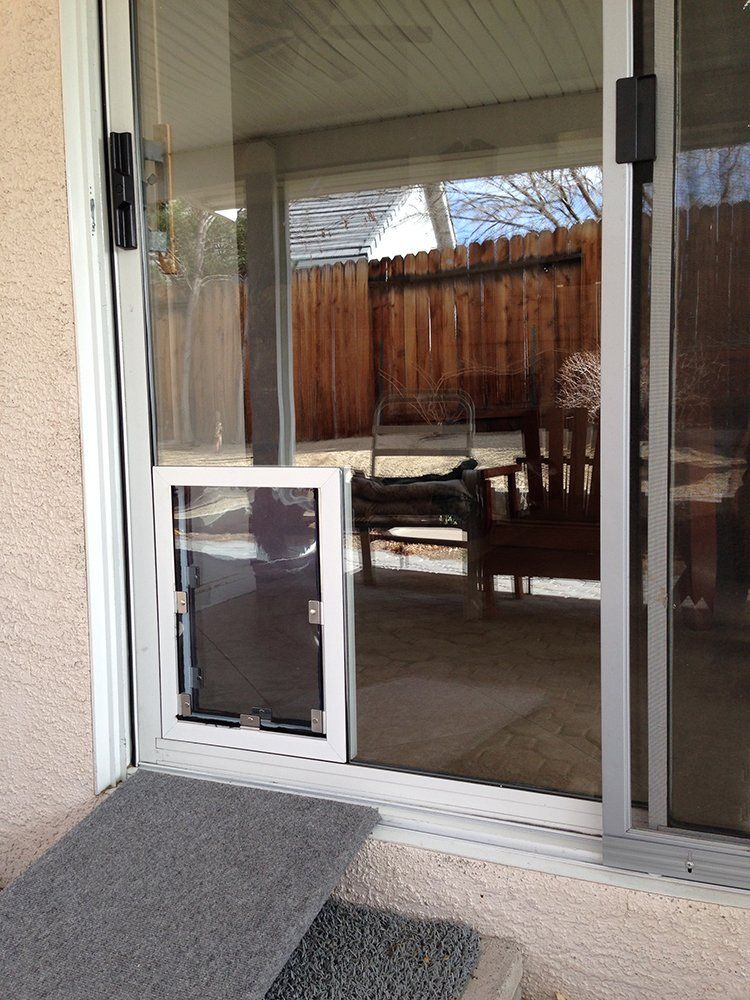 A sliding glass door with a dog door in it