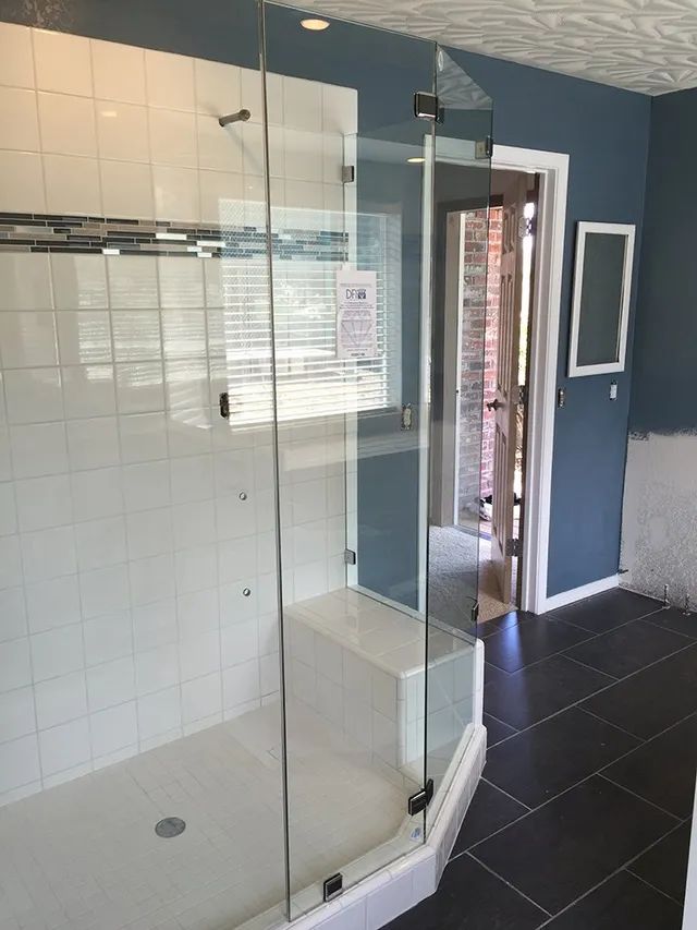 A bathroom with a walk-in shower with a glass door