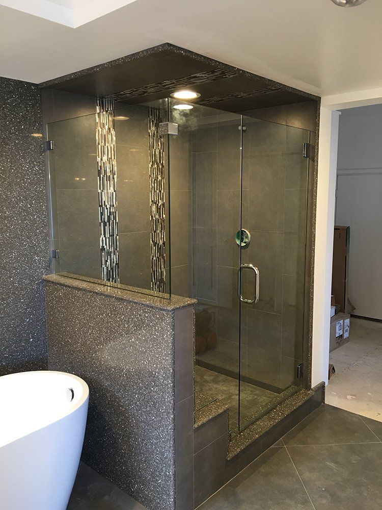 A bathroom with a bathtub and a shower with a glass door