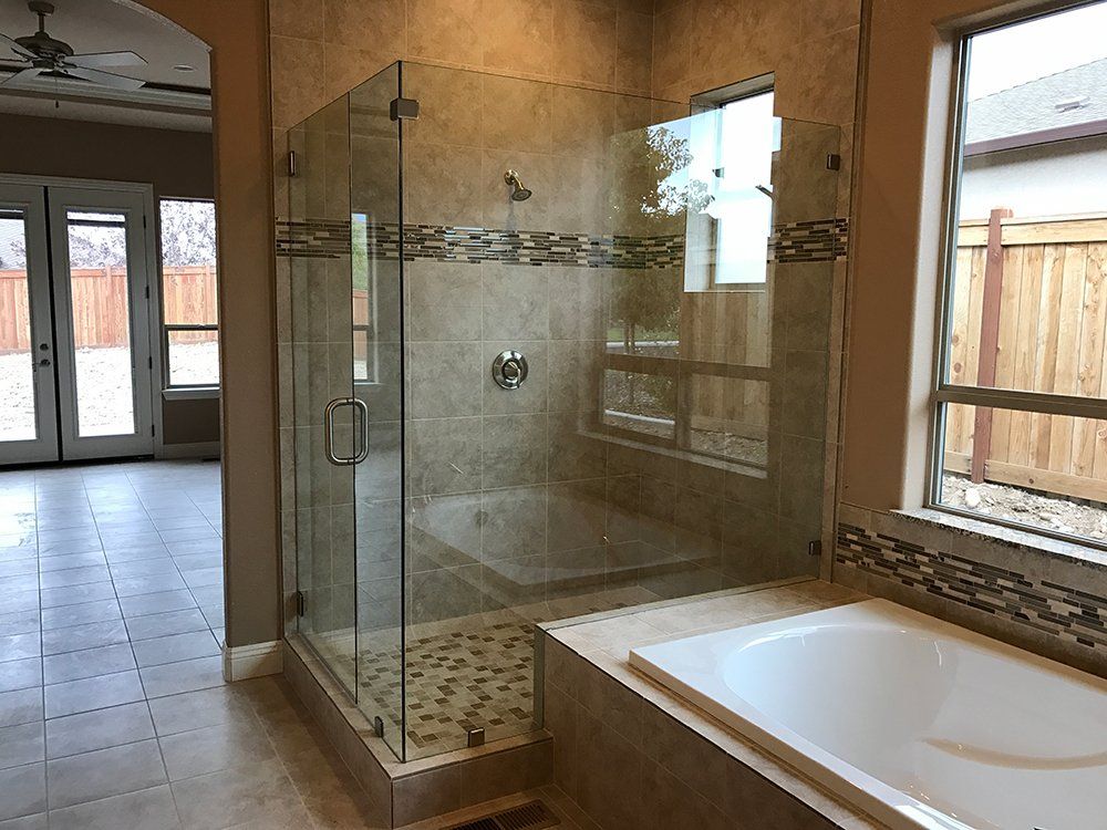 A bathroom with a walk in shower and a bathtub