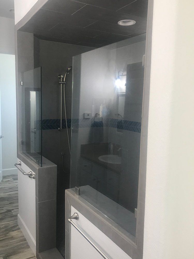 A bathroom with a walk in shower and a sink