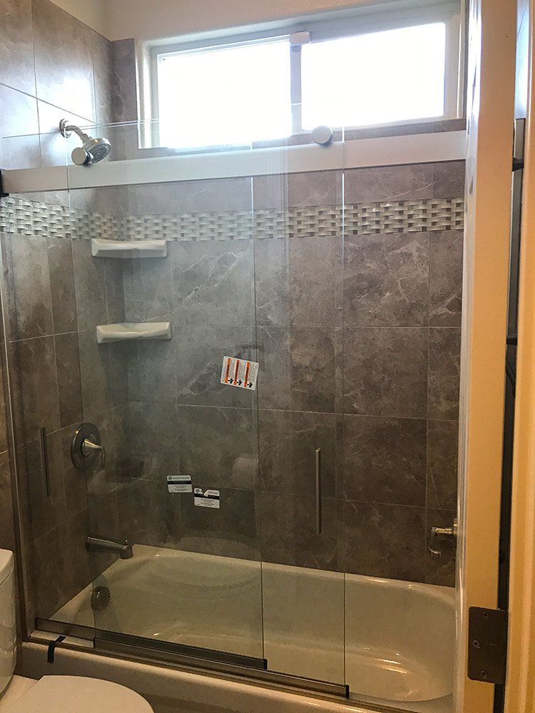 A bathroom with a tub and a shower with a glass door