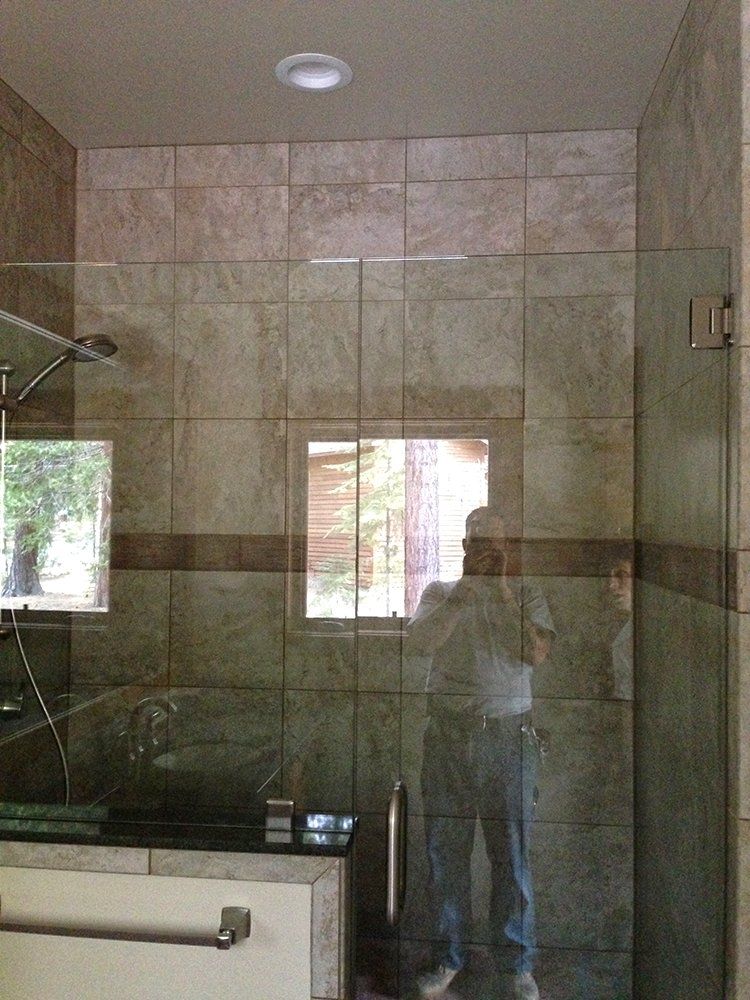 A man is taking a picture of himself in a shower stall