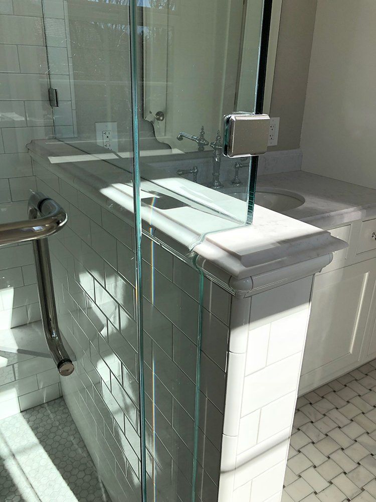 A bathroom with a sink and a glass shower door