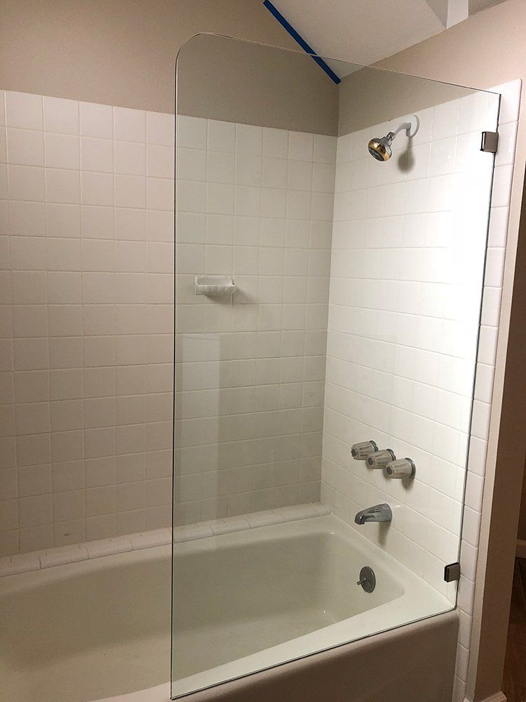 A bathroom with a bathtub and a shower with a glass door