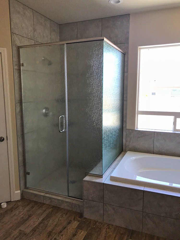 A bathroom with a tub, shower, and window