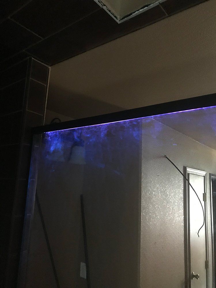 A bathroom with a shower curtain with purple lights on it