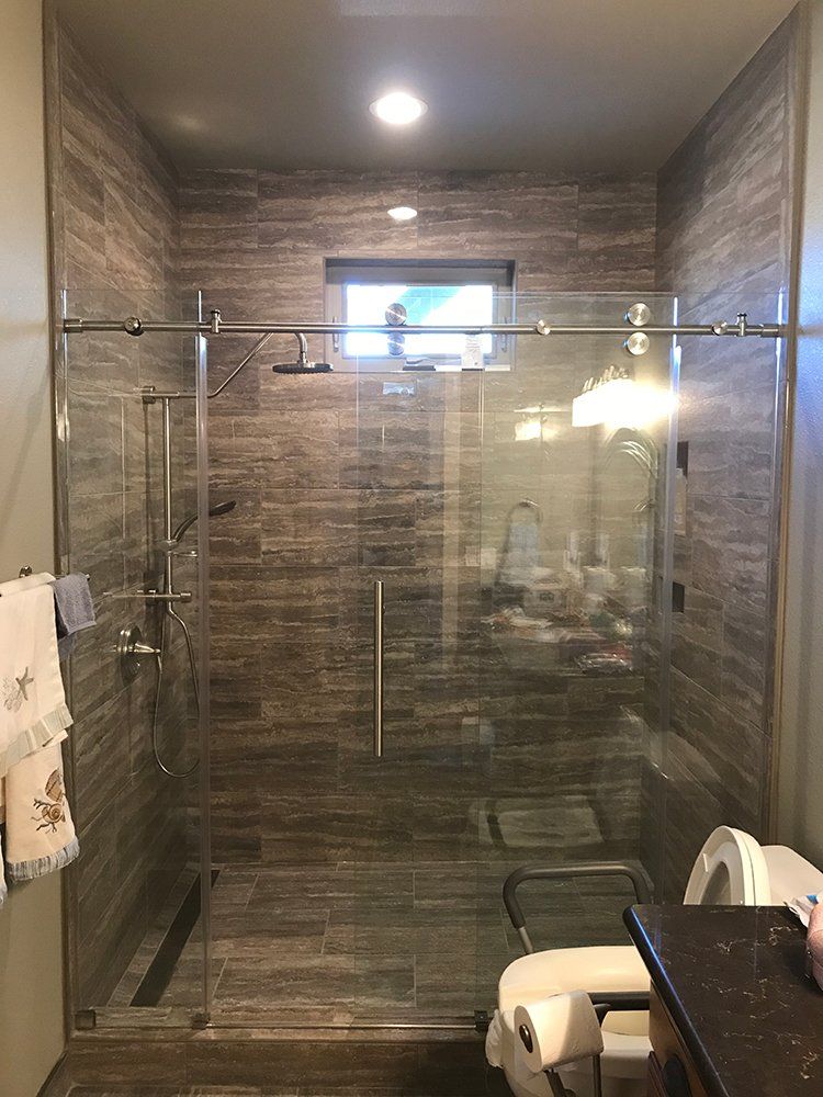 A bathroom with a sliding glass shower door and a toilet