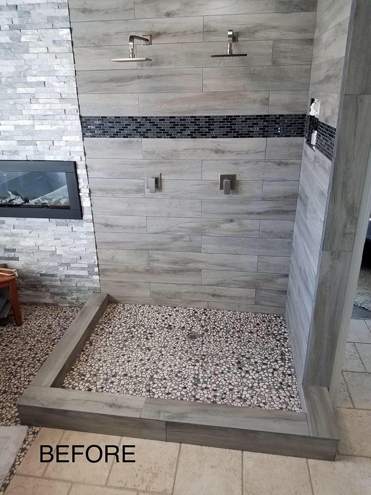 A bathroom with a walk in shower and a fireplace