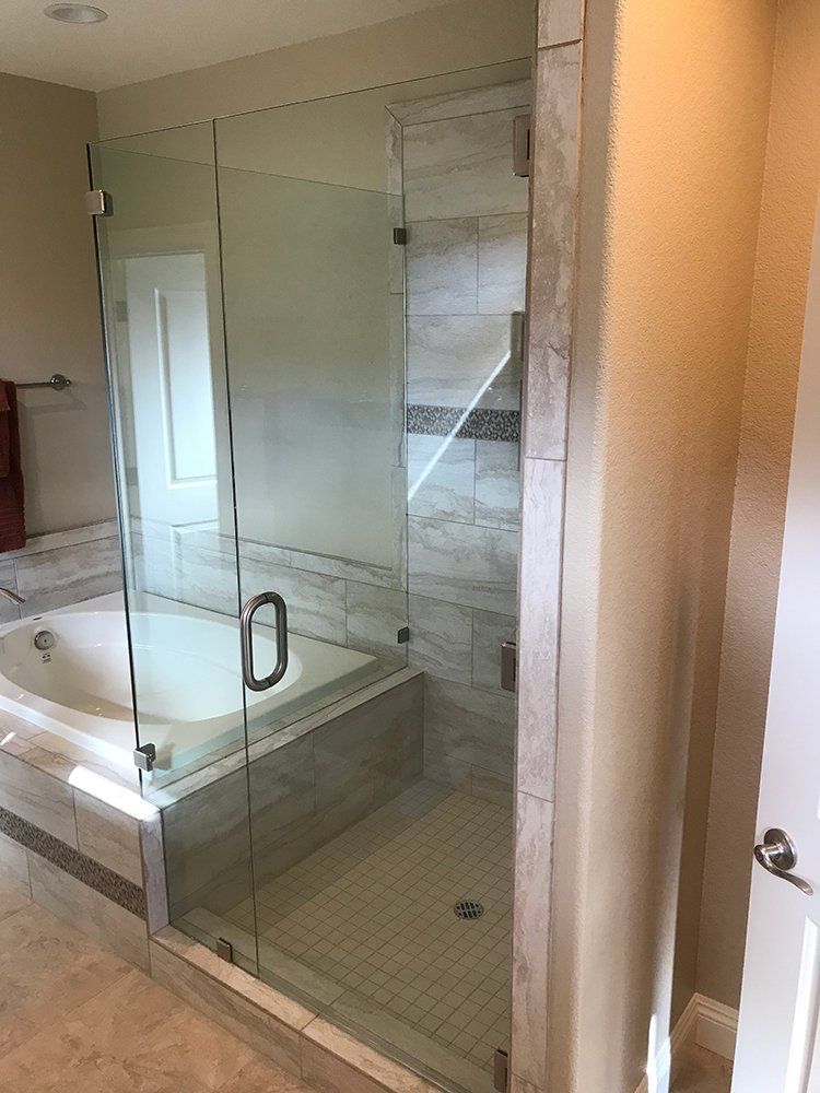 A bathroom with a bathtub and a glass shower door