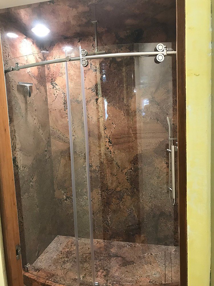 A shower stall with a sliding glass door in a bathroom