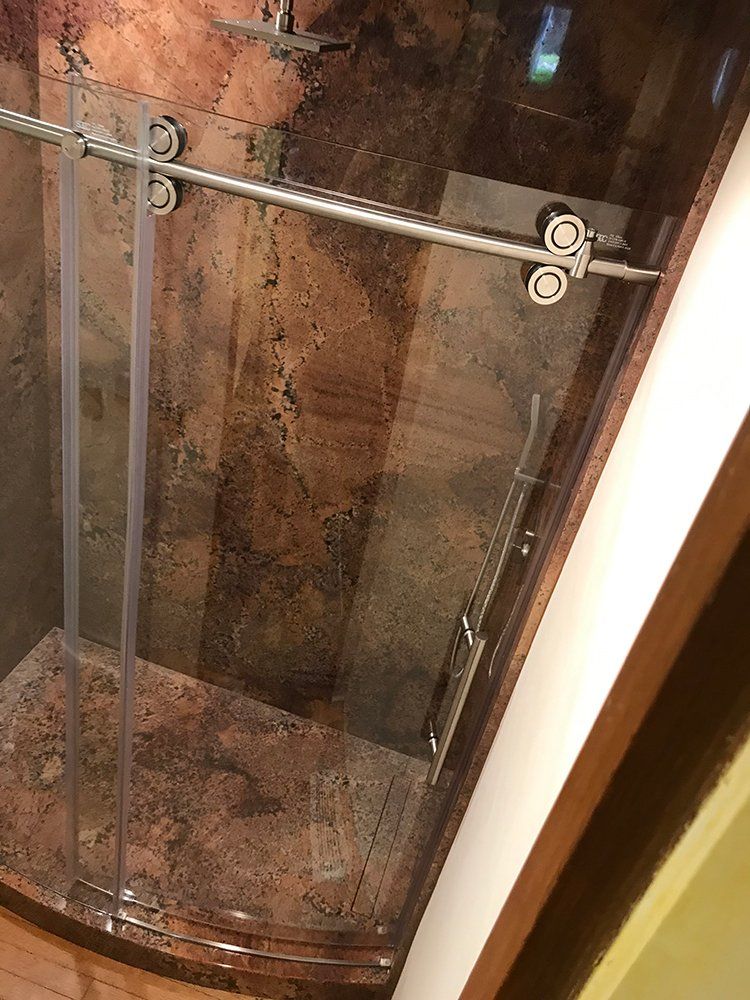 A shower stall with a sliding glass door in a bathroom