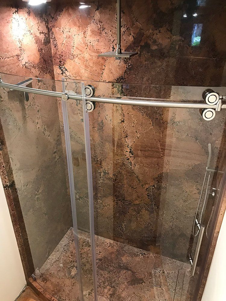 A shower stall with a sliding glass door in a bathroom