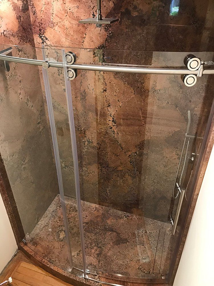 A shower stall with a sliding glass door in a bathroom