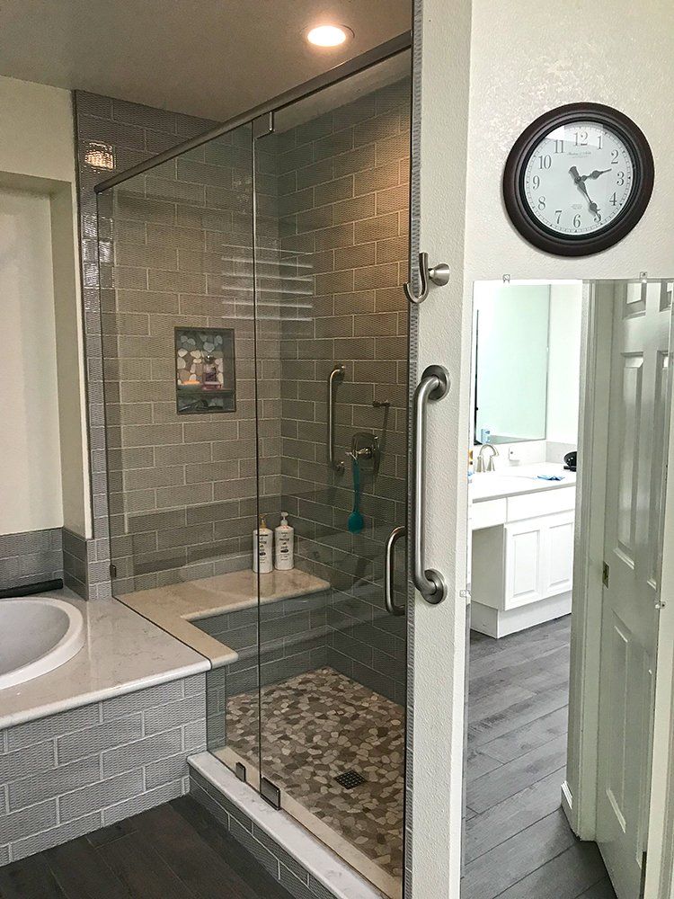 A bathroom with a walk in shower and a clock on the wall
